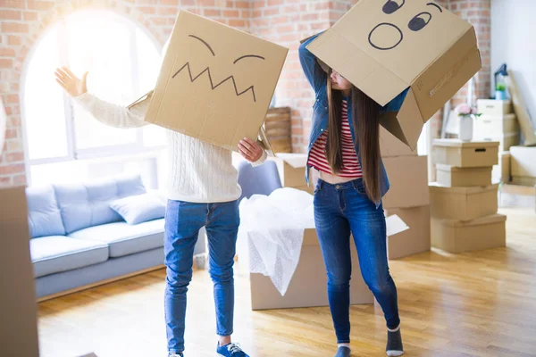 Çılgın çift kafa üzerinde komik yüzler ile kutuları giyiyor, yeni bir eve taşımak için mutlu eğlenceli