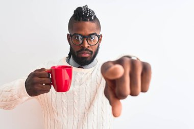 Izole beyaz arka plan üzerinde kahve içme örgülü Afro-amerikan adam kameraya parmak ile işaret ve size, el işareti, önden olumlu ve kendinden emin jest