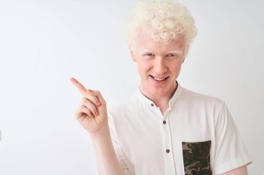 Genç albino sarışın adam izole beyaz arka plan üzerinde duran rahat gömlek giyen çok mutlu yan el ve parmak ile işaret