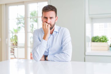 Yakışıklı iş adamı vurguladı ve ağız ısırma tırnakları ile gergin bakıyor. Anksiyete sorunu.