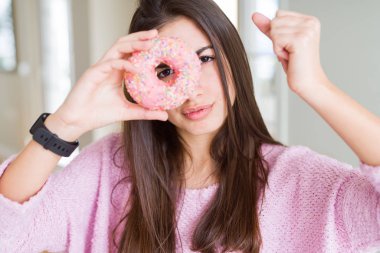 Pembe çikolata cips yeme güzel genç kadın çörek rahatsız ve sinirli öfke ile bağırarak, deli ve yükseltilmiş el, öfke kavramı ile bağırarak