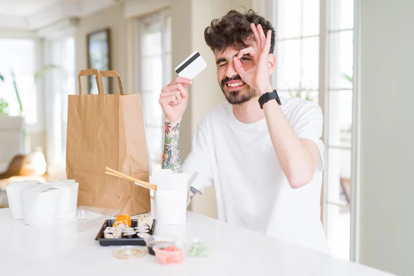 Joven Comiendo Sushi Asiático Entrega Domicilio Usando Tarjeta Crédito Como — Foto de Stock