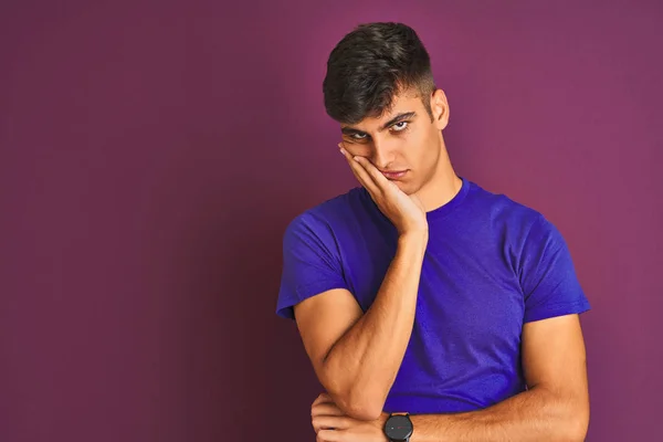 Young indian man wearing t-shirt standing over isolated purple background thinking looking tired and bored with depression problems with crossed arms.