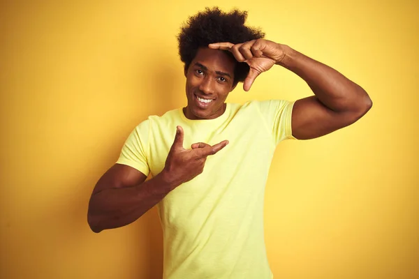 非洲裔美国男子 一个非洲头发 穿着T恤站在孤立的黄色背景微笑 用手和手指与快乐的脸框架 创意与摄影理念 — 图库照片