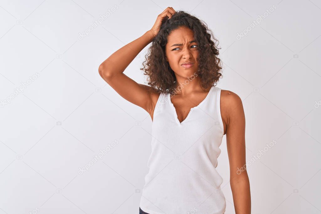 Young brazilian woman wearing casual t-shirt standing over isolated white background confuse and wondering about question. Uncertain with doubt, thinking with hand on head. Pensive concept.