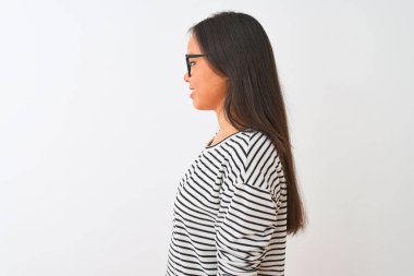 İzole beyaz arka plan üzerinde çizgili t-shirt ve gözlük giyen genç Çinli kadın yan bakarak, kendine güvenen gülümseme ile doğal yüz ile profil poz dinlenmek.