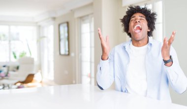 Afrika kökenli Amerikalı adam evde deli ve çığlık kaldırdı ve kapalı gözleri heyecanlı silah ile başarı için deli kutluyor. Kazanan kavramı