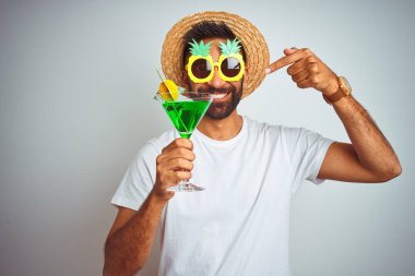Hint adam yaz komik bakmak izole beyaz arka plan üzerinde kokteyl içme giyen çok mutlu el ve parmak ile işaret