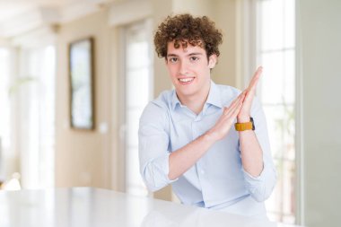 Kıvırcık okunan baş alkışlayan ve mutlu ve neşeli alkışlayan genç iş adamı, birlikte gururlu eller gülümseyen