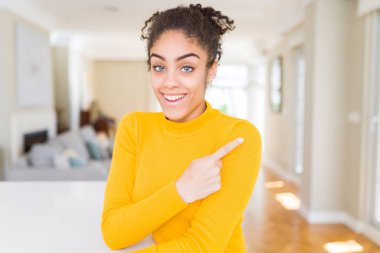 Neşeli bir gülümseme ile el ve parmak kadar yan yüzünde mutlu ve doğal ifade ile işaret yüz afro saçlı güzel genç Afro-Amerikan kadın