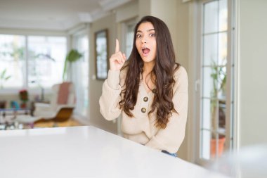 Genç güzel kadın evde parmak ile başarılı fikir işaret. Çıktıktan ve mutlu. Bir numara.