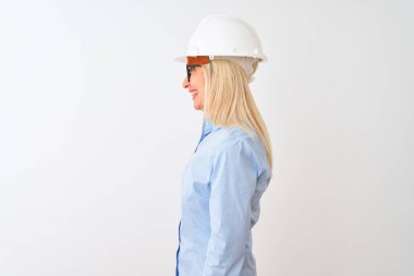 Orta yaş mimar kadın yan bakarak izole beyaz arka plan üzerinde gözlük ve kask giyen, kendine güvenen gülümseme ile doğal yüz ile profil poz dinlenmek.