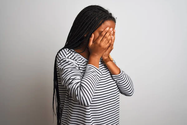 白い背景の上にストライプのTシャツを着た若いアフリカ系アメリカ人女性が泣きながら手で顔を覆う悲しい表情で立っている うつ病の概念 — ストック写真