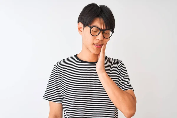 メガネをかけた中国人男性とネイビーのストライプのTシャツを着た中国人男性は 歯痛や歯の病気のために痛みを伴う表情で口に触れ 孤立した白い背景の上に立っている 歯科医の概念 — ストック写真
