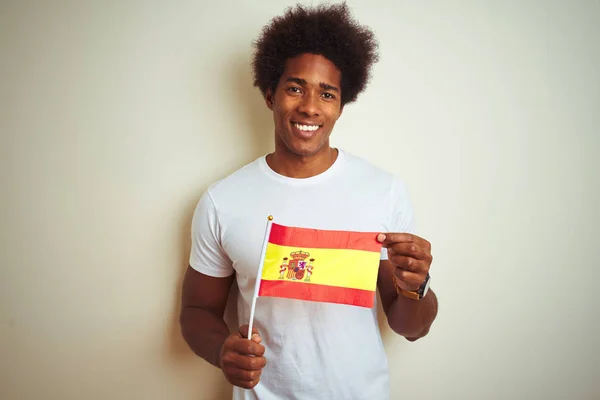 孤立した白い背景の上に立つスペインのスペイン国旗を持つ若いアフロアメリカ人男性は 歯を見せる自信に満ちた笑顔で立ち上がり 微笑んでいる — ストック写真