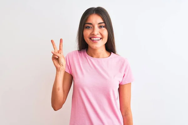 분홍색 캐주얼 티셔츠를 고립된 자신감과 행복한 미소를 지으면서 손가락 가리키고 — 스톡 사진