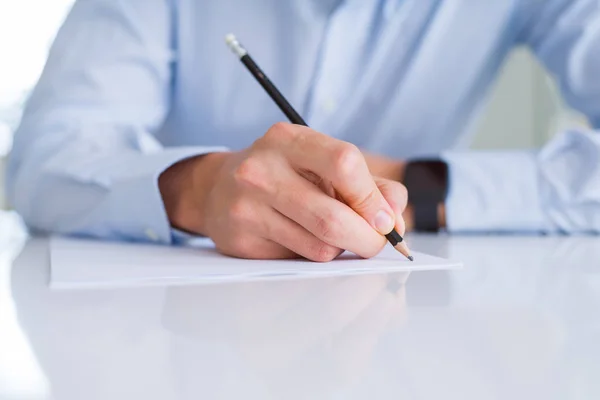 Close up of man hands writing using a pencil on paper over white Stock Photo