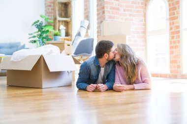 Yeni bir eve taşımak için etrafında karton kutular ile birlikte katta yatarken rahatlatıcı aşk genç güzel çift