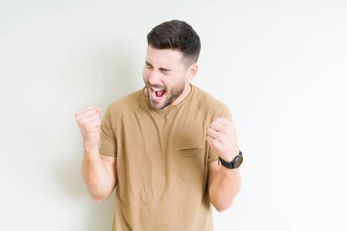 Soyutlanmış, mutlu ve heyecanlı genç bir adam kollarını kaldırmış, gülümseyen ve başarı için çığlık atan kazanan bir jest yapıyor. Kutlama konsepti.