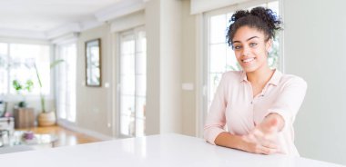 Afro saçlı güzel afro-amerikan kadın geniş açı neşeli sunan palmiye avuç içi yardım ve kabul veren gülümseyen.