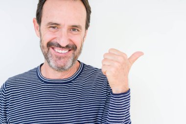 Seyir ve başparmak yanında yukarıyı mutlu yüz ile gülümseyen izole arka plan üzerinde üst düzey yakışıklı.