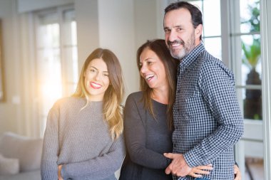 Güzel aile birlikte. Anne, baba ve kızı gülümseyen ve evde sevgi ile sarılma.
