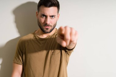 İzole edilmiş arka planda genç yakışıklı bir adam kamerayı işaret ediyor ve sen, el işareti, ön taraftan pozitif ve kendinden emin bir hareket.