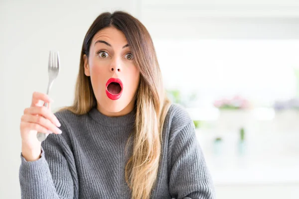 Young Beautiful Woman Holding Silver Fork Home Scared Shock Surprise — Stock Photo, Image