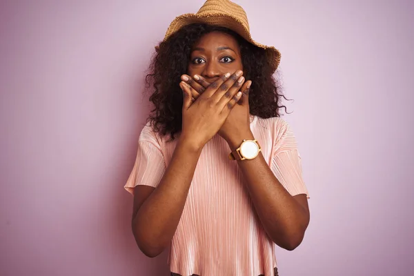 孤立したピンクの背景の上にTシャツと帽子をかぶった若いアフリカ系アメリカ人女性は 間違って手で口を覆うショックを受けました 秘密の概念 — ストック写真