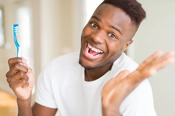 African American Mężczyzna Trzyma Szczoteczkę Zębów Bardzo Szczęśliwy Podekscytowany Wyrażenie — Zdjęcie stockowe