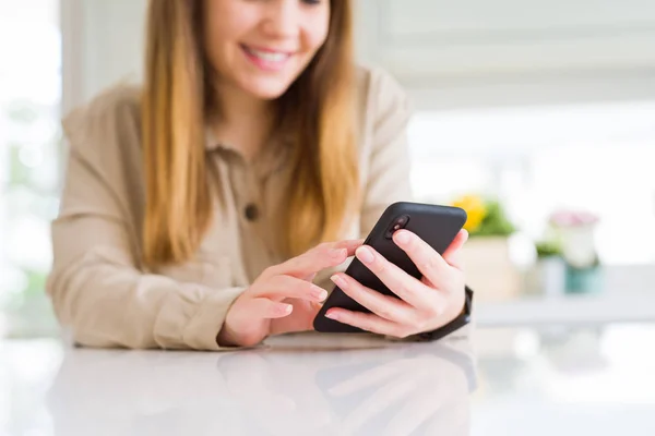 Close-up van de vrouw met behulp van smartphone en glimlachend zelfverzekerd — Stockfoto