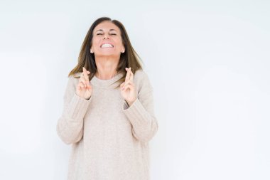 Umut ve gözleri kapalı geçiş parmaklarıyla gülümseyen izole arka plan güzel orta yaş kadın. Şans ve batıl kavramı.