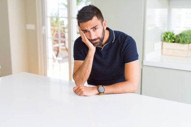 Yakışıklı İspanyol adam evde yorgun görünümlü ve çapraz kolları ile depresyon sorunları ile sıkılmış düşünme.