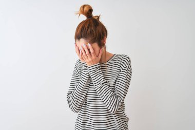 Kırmızı saçlı kadın lacivert çizgili t-shirt giyerek izole beyaz arka plan üzerinde ayakta üzgün ifade ile elleri ile yüz kapsayan ağlarken. Depresyon kavramı.