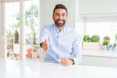 Yakışıklı İspanyol iş adamı tebrik ve karşılama olarak el sıkışma sunan dostu gülümseyen. Başarılı iş.