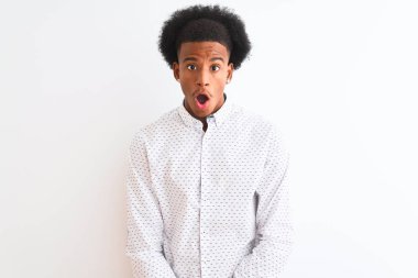 Genç afro-Amerikan adam izole beyaz arka plan üzerinde duran zarif gömlek giyen korkmuş ve sürpriz ifade, korku ve heyecanlı yüz ile şok.