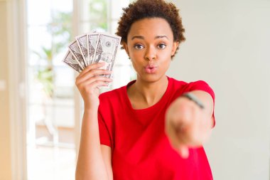 Genç Afro-Amerikan kadın holding banknot, elli dolar kamera ve size parmak ile işaret, el işareti, pozitif ve kendinden emin bir jest ön