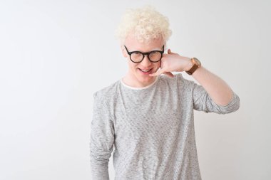 Genç albino sarışın adam çizgili t-shirt ve gözlük izole beyaz arka plan üzerinde telefon hareket le telefon jest yapıyor gülümseyerek giyen telefonda konuşurken gibi. İletişim kavramları.