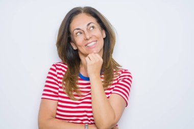 Orta yaş üst düzey kadın beyaz izole arka plan üzerinde el çene üzerinde soru hakkında düşünme, dalgın ifade ayakta. Düşünceli bir yüz ile gülümsüyor. Şüphe kavramı.