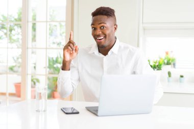 Başarılı bir fikir ile parmak işaret dizüstü bilgisayar kullanarak çalışan Afro-Amerikan iş adamı. Çıktı ve mutlu. Bir numara.