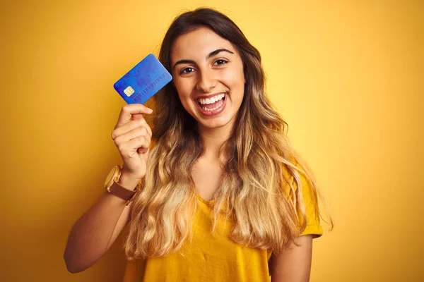 Młoda Piękna Kobieta Trzyma Kartę Kredytową Żółtym Białym Tle Szczęśliwą — Zdjęcie stockowe