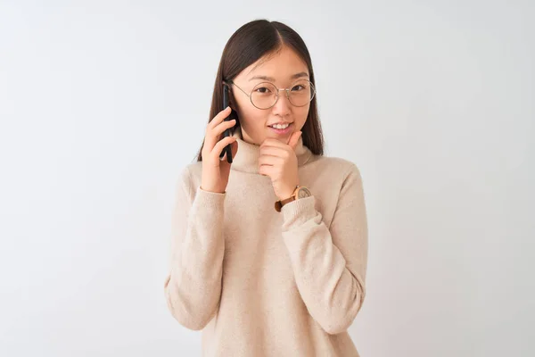 年轻的中国妇女说话的智能手机上孤立的白色背景 看着自信的相机微笑与交叉的手臂和手抬起下巴 积极思考 — 图库照片