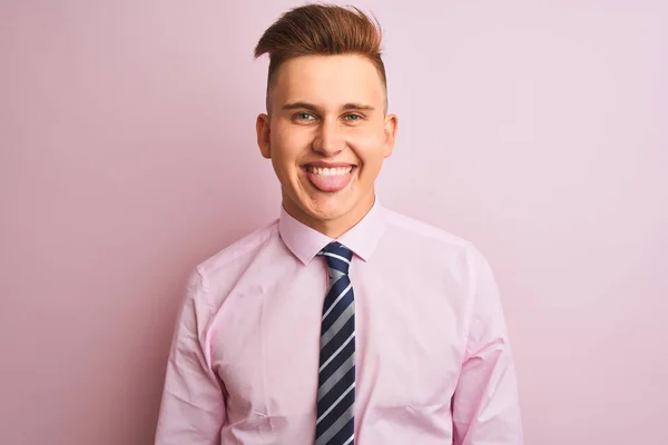 年轻英俊的商人穿着衬衫和领带站在孤立的粉红色背景坚持舌头与有趣的表情高兴 情感概念 — 图库照片