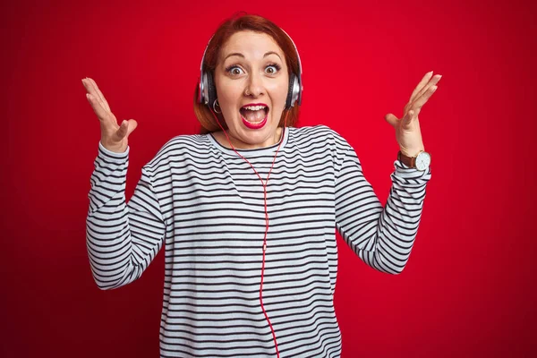 Ung Rödhårig Kvinna Lyssnar Musik Med Hörlurar Över Röd Isolerad — Stockfoto
