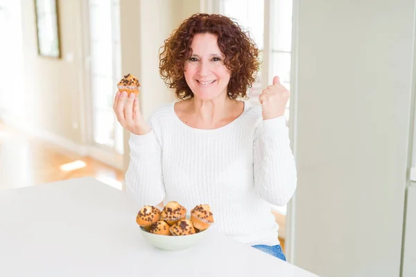 Senior Woman Eating Chocolate Chips Muffins Screaming Proud Celebrating Victory — Stock Photo, Image