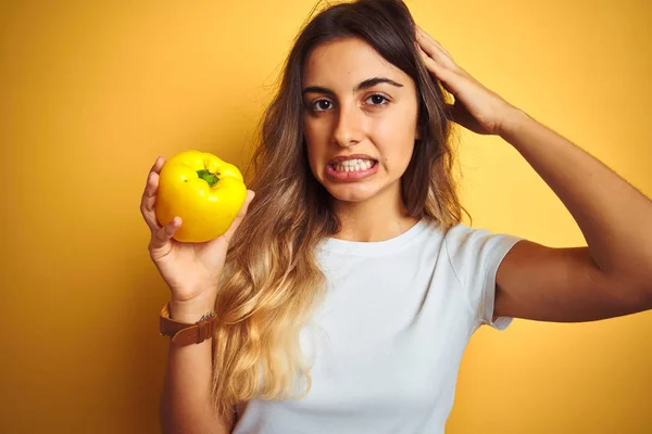 Jovem Bela Mulher Segurando Pimenta Sobre Fundo Isolado Amarelo Estressado — Fotografia de Stock