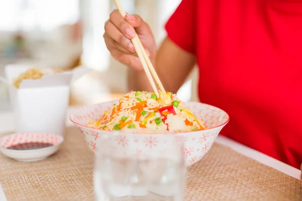 Close up de mulher comer arroz asiático usando pauzinhos — Fotografia de Stock