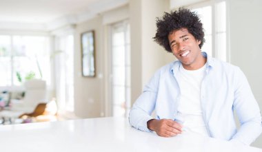 Evde Afrikalı Amerikalı adam seksi ifade, neşeli ve mutlu yüz ile kamera bakarak göz kırpıyor.