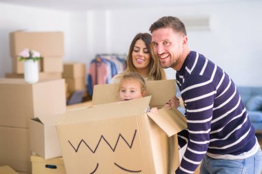 Güzel famiily, yeni evde bel karton kutu sürme ailesi ile oynayan çocuk