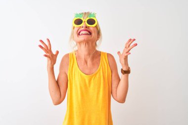 Tatilde orta yaşlı kadın izole beyaz arka plan üzerinde ananas güneş gözlüğü giyen kollarını kaldırdı ve kapalı gözleri heyecan çığlık ile başarı için deli ve deli kutluyor. Kazanan kavramı